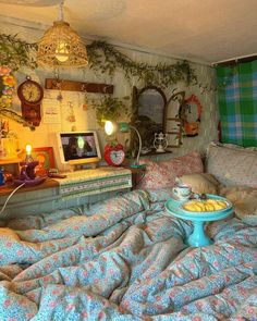 a bed with blue and pink bedspread next to a table filled with food