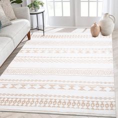 a living room area with a white rug and two vases sitting on the floor