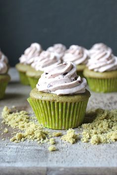 green cupcakes with white frosting and sprinkles