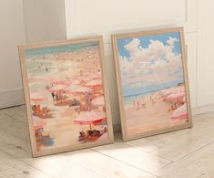 two framed pictures with umbrellas on a wooden floor next to each other in front of a white wall