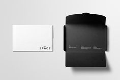 a black and white business card next to an envelope with the word space on it