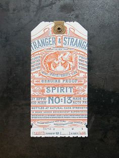 an orange and white label on the side of a black surface that says, ranger & strange spirit no 13