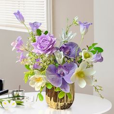 a vase filled with purple flowers sitting on top of a table