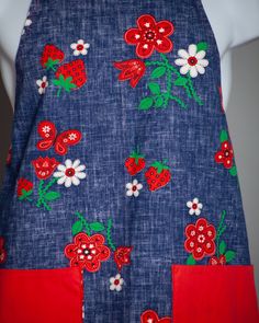 a blue apron with red and white flowers on it