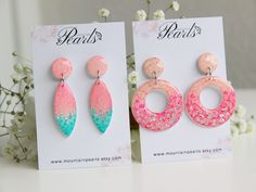 two pairs of pink and blue earrings on display