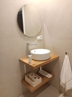 a bathroom with a sink, mirror and towel on the shelf in front of it