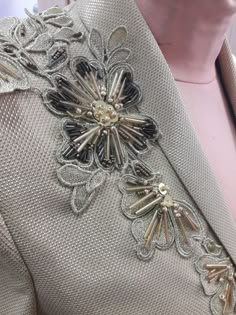 a close up view of a jacket with flowers on the front and back, in gold