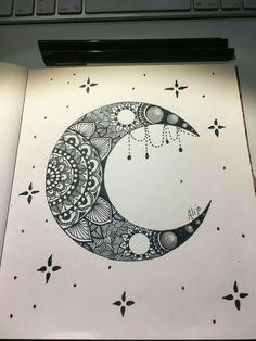 an open notebook with a drawing of a crescent moon on the cover and stars in the background