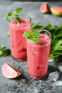 two glasses filled with watermelon smoothie and garnished with mint leaves