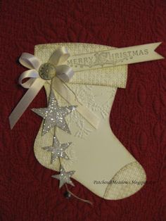 a white christmas stocking with silver stars on it and a ribbon around the boot