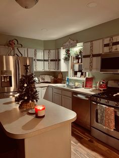 a christmas tree sits on the kitchen counter next to an oven and stove with candles in it