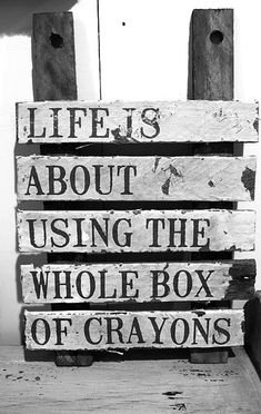 a wooden sign that says life is about using the whole box of crayons