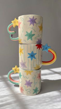 three stacking cups with different designs on them