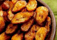 a bowl filled with sliced bananas sitting on top of a green cloth covered tablecloth