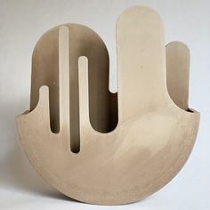 a sculpture made out of clay on a white surface with holes in the middle and one hole at the bottom