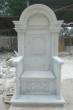 a white marble bench sitting on top of a cement slab