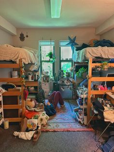 a room filled with bunk beds and lots of clutter on top of the floor