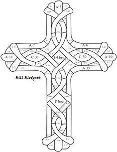 a cross that has been made out of different types of knots and numbers on it