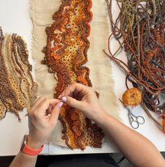 a woman is working on an art project with crochet and yarns in the background