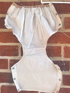 a white cloth diaper hanging on a brick wall