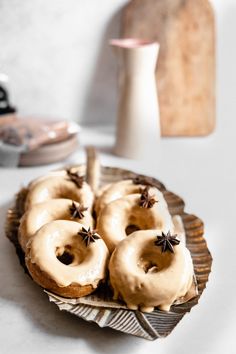 there are donuts with icing and cinnamon stars on them in a plate next to a vase