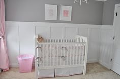 a white crib in a pink and gray nursery