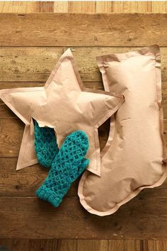 a stuffed star sitting on top of a pillow next to a pair of mittens