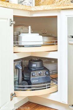 an open kitchen cabinet with appliances in it