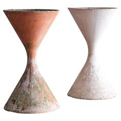 two vases sitting side by side on a white background