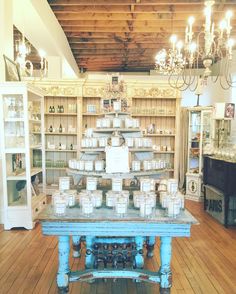 a table with candles on it in a room filled with shelves and chandeliers