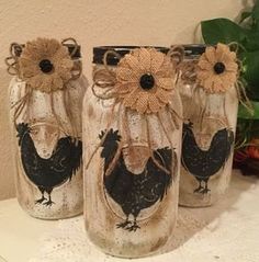 three mason jars decorated with burlocks and roosters are sitting on a table