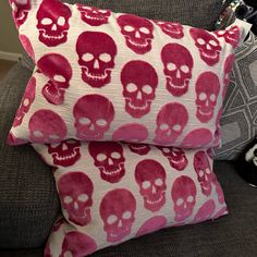 two pillows with skulls on them sitting on a couch