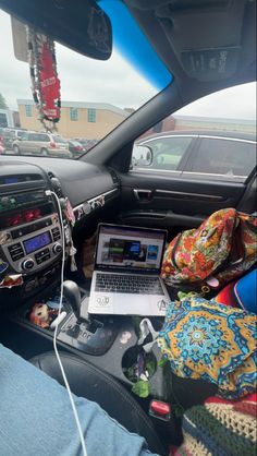 a laptop computer sitting on top of a table in the back seat of a car