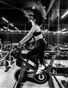 a woman riding an exercise bike in a gym