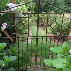 an open gate in the middle of a garden