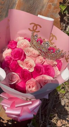 a bouquet of pink roses with a tiara on top