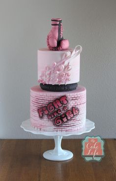 a three tiered cake decorated with pink and black decorations