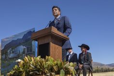 a man standing at a podium in front of two children