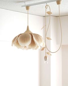 a light fixture hanging from the ceiling in a room with white walls and flooring