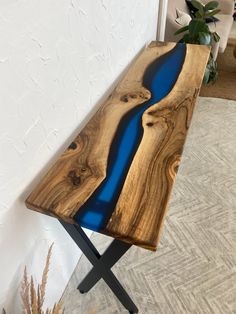 a bench made out of wood with blue paint on the top and black metal legs