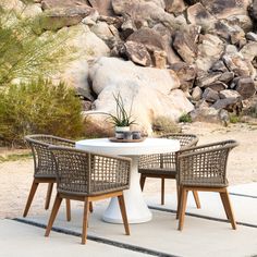 two chairs and a table in front of some rocks