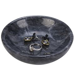 a black marble bowl sink with two gold rings on the bottom and one ring in the middle