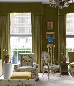 an instagram photo of a living room with green walls and curtains on the windows