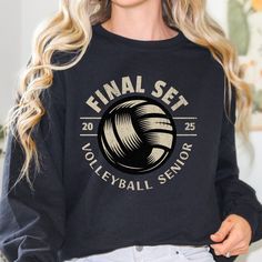 a woman wearing a black sweatshirt with the words final set volleyball seniors on it in white