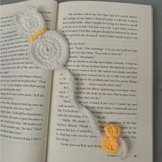 an open book with a crocheted brooch on it's cover and the pages are white