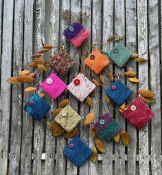 a group of small purses sitting on top of a wooden table next to leaves