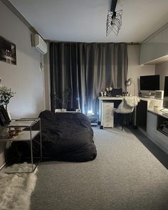 a bedroom with a bed, desk and television in it