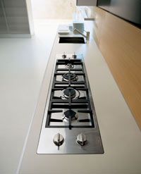 a stove top oven sitting inside of a kitchen next to a counter with pots and pans on it