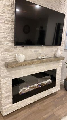 a flat screen tv mounted on the wall above a fireplace