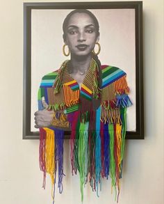 a framed photograph of a woman with multicolored fringes